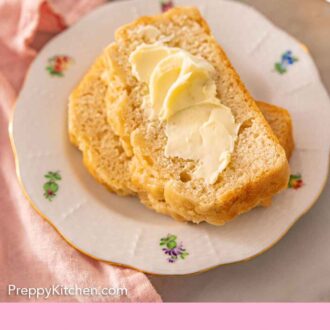 Pinterest graphic of two slices of beer bread on a plate with butter spread on the top slice.