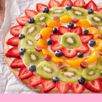 Pinterest graphic of a fruit pizza with cut grapes and blueberries on a plate in the background.