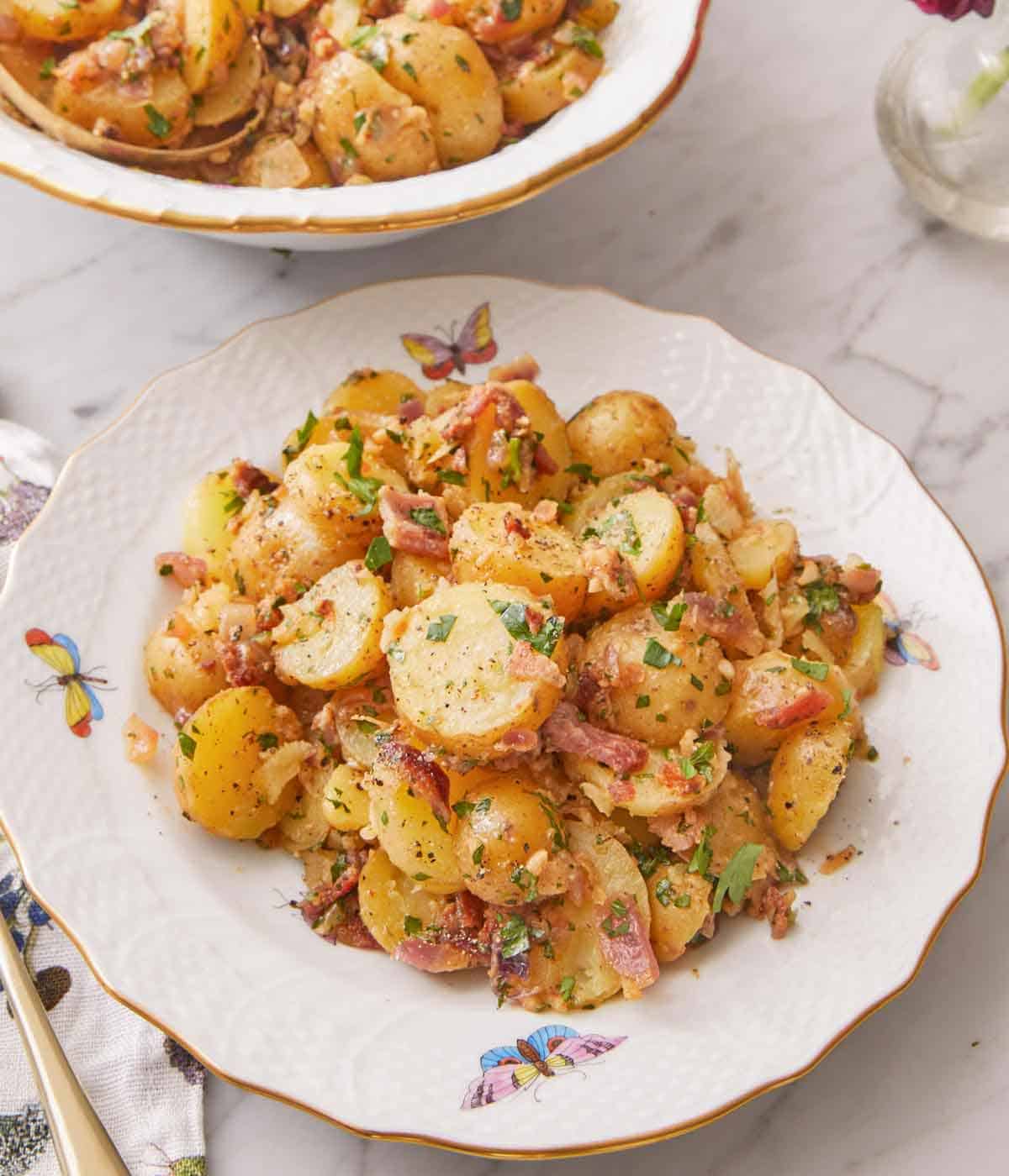 A plate of German potato salad with fresh parsley garnished on top.