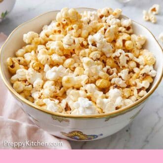 Pinterest graphic of a bowl of kettle corn with flowers in the background.