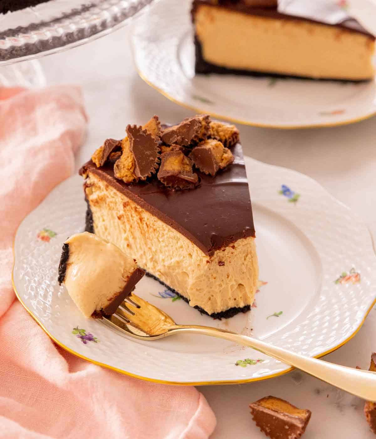 A plate with a slice of peanut butter cheesecake with the tip on a fork.