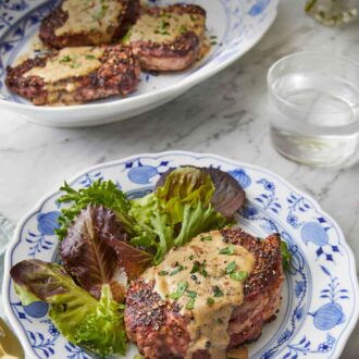 Pinterest graphic of a plate of steak au poivre with mixed greens in front of a platter of three more steak au poivre.