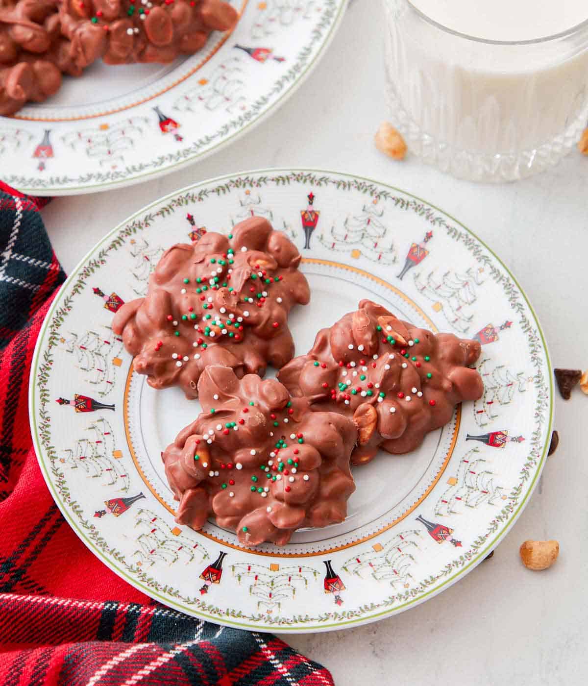 Overhead view of a plate with three crockpot candies with some milk in the background.
