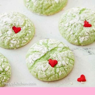 Pinterest graphic of multiple Grinch cookies with a heart sprinkle pressed on each other them.