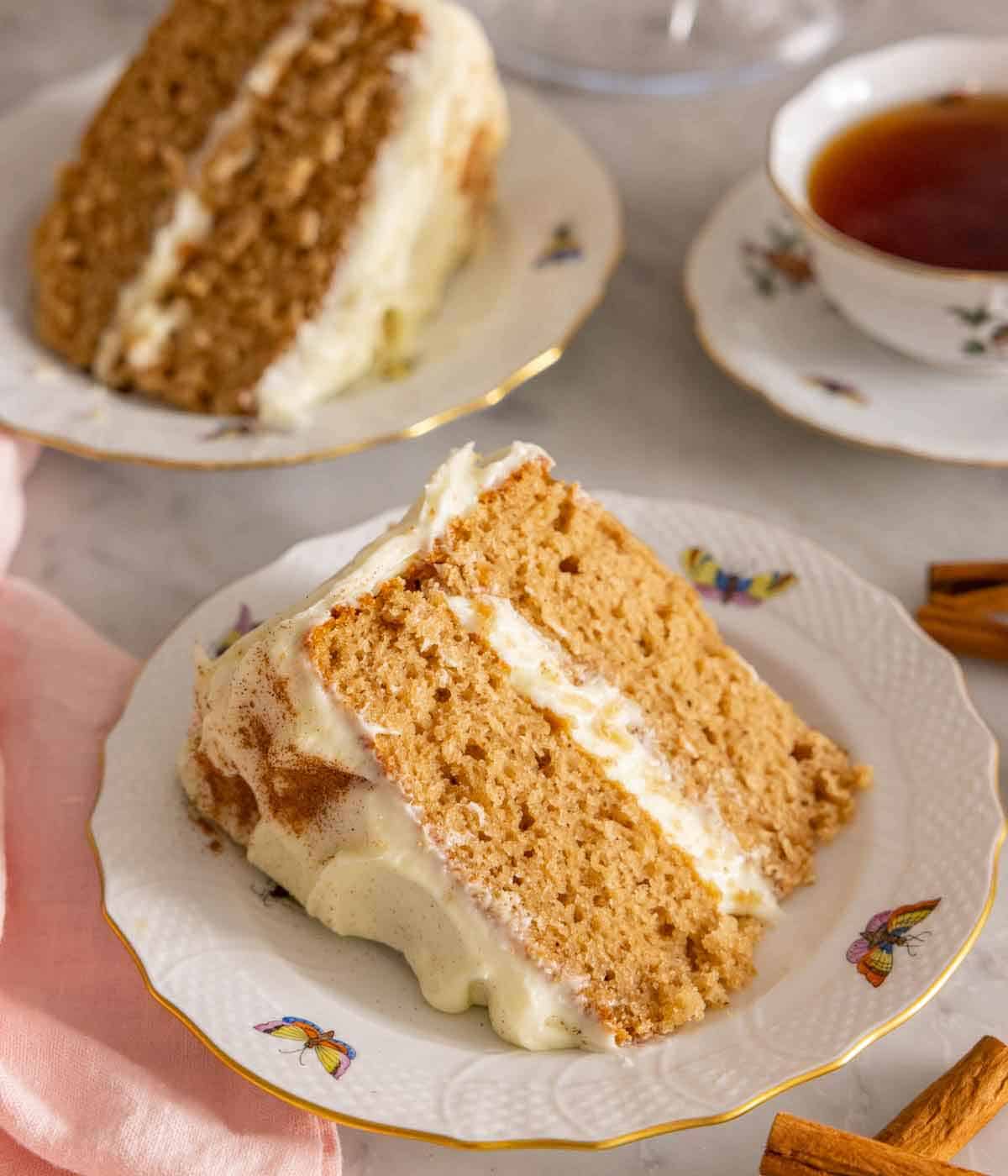 Two plates with a slice of spice cake on each, one plate is front and center.
