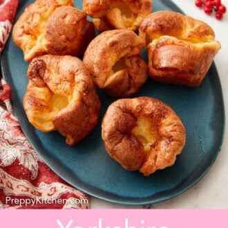 Pinterest graphic of an overhead view of a blue oval plate with multiple Yorkshire pudding.