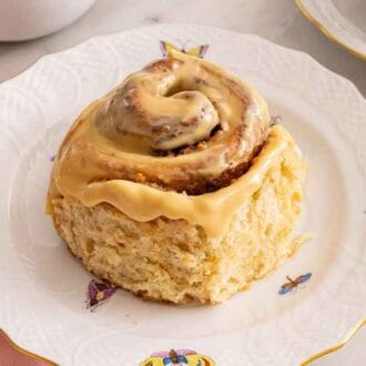 Pinterest graphic of a dulce de leche cinnamon roll on a plate.