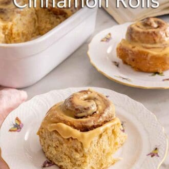 Pinterest graphic of a plate with a dulce de leche cinnamon roll with another in the background.