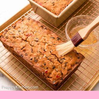 Pinterest graphic of alcohol brushed onto a loaf of fruit cake.