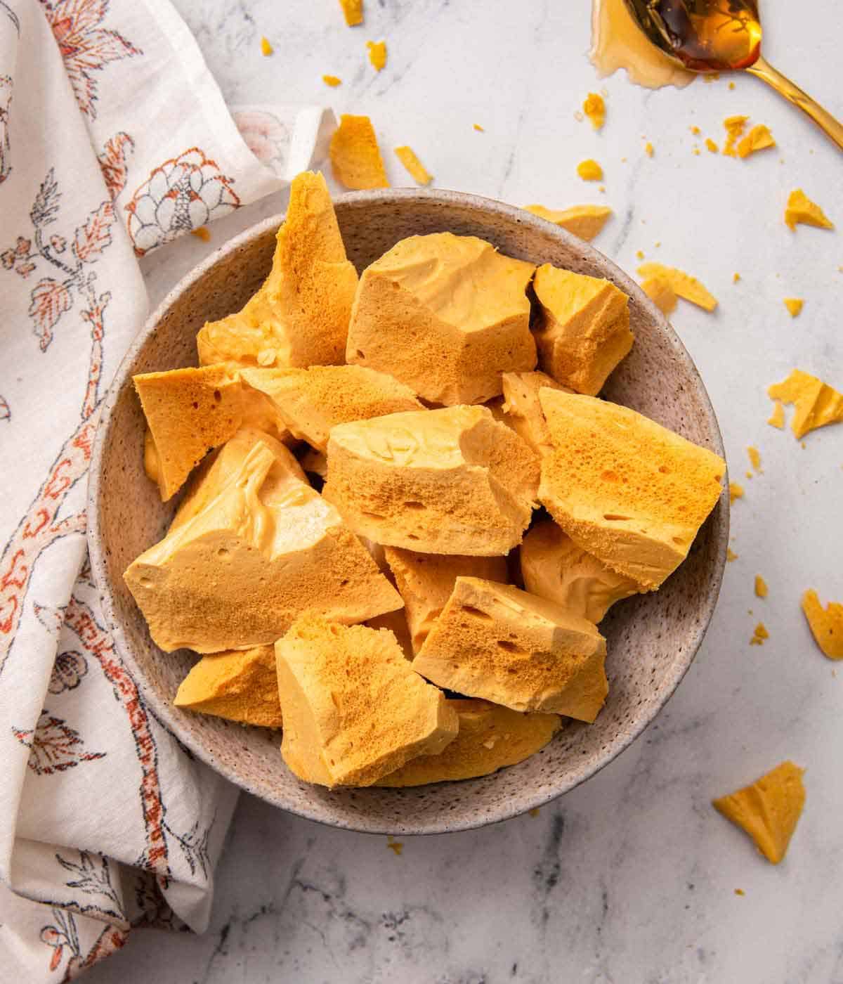 Overhead view of a bowl of pieces of honeycomb.