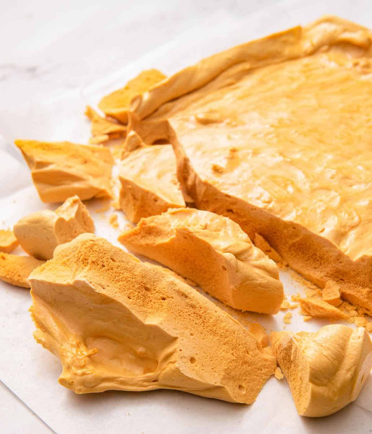 A slab of honeycomb with pieces in front broken off.