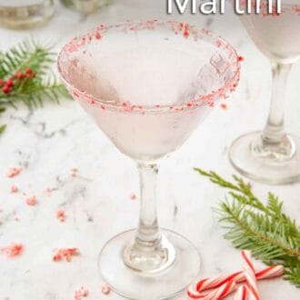 Pinterest graphic of a glass of peppermint martini with crushed and whole peppermint candies scattered around with greenery.
