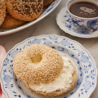 Pinterest graphic of a plate with a sliced bagel with cream cheese spread inside.