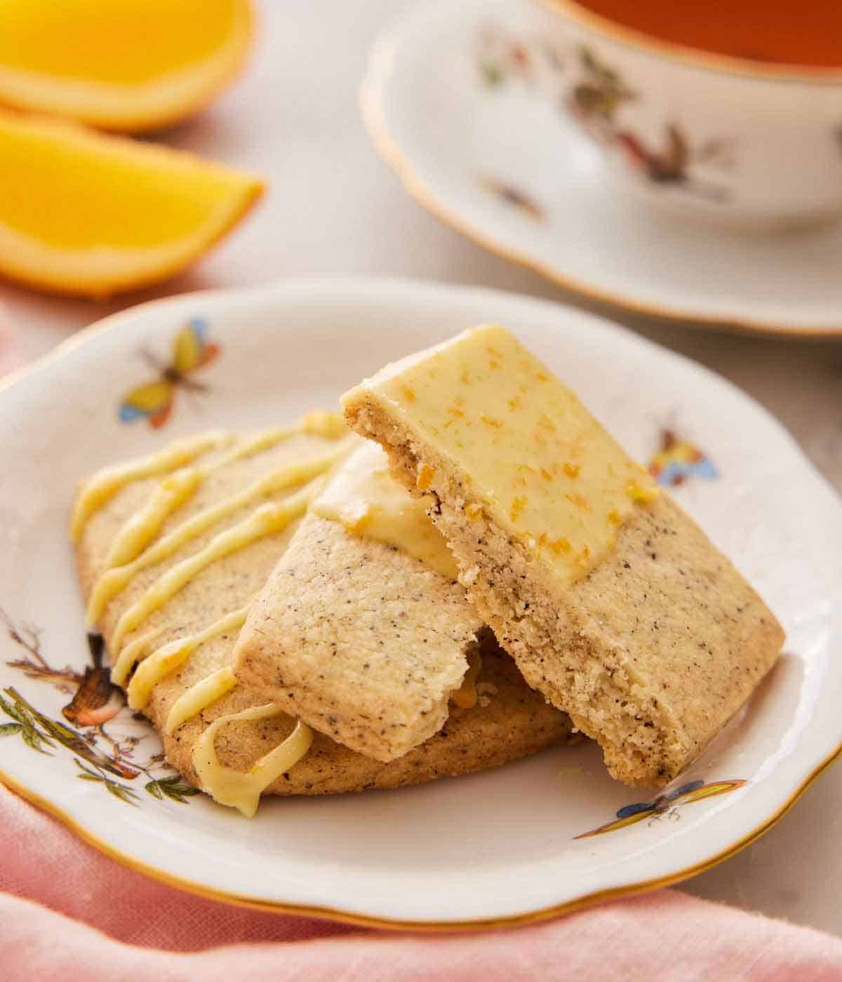 A plate with two browned butter-earl grey cookies, one broken in half to show the crumb.