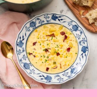 Pinterest graphic of an overhead view of a bowl of corn chowder with some bread and the pot of chowder on the side.