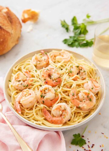 A bowl of pasta topped with shrimp scampi.