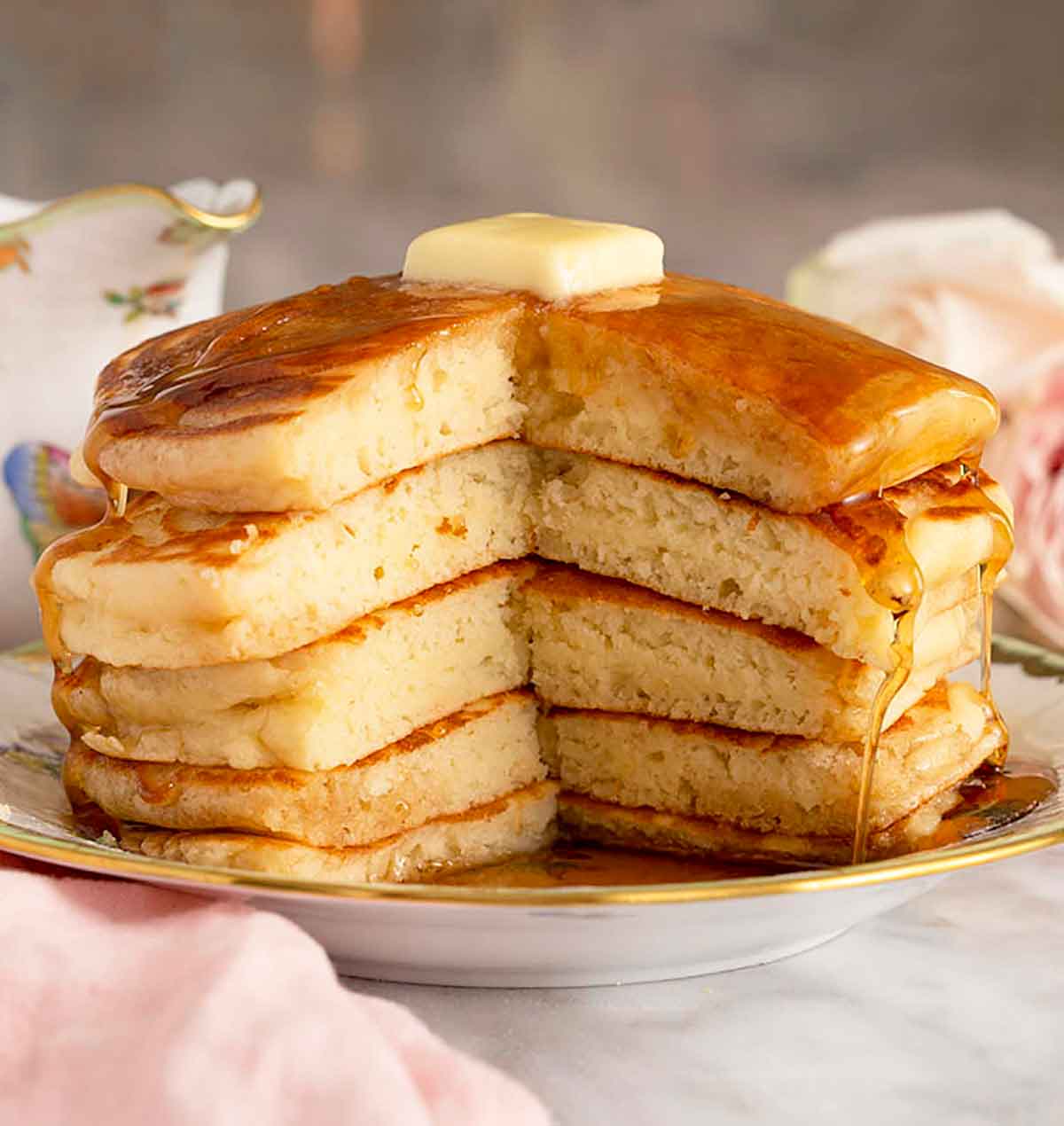 Five pancakes on a place with a big piece cut out, showing the middle.