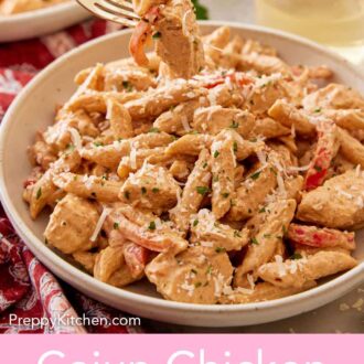 Pinterest graphic of a forkful of Cajun chicken pasta lifted out of the plate.