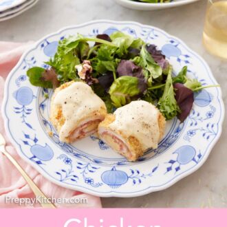 Pinterest graphic of a plate with a serving of chicken cordon bleu cut in half with salad beside it.