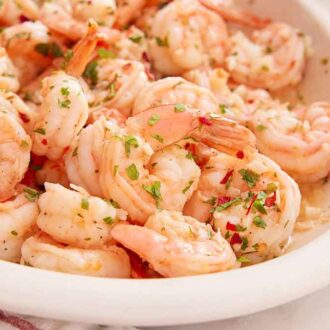 Close up view of a platter of garlic shrimp.