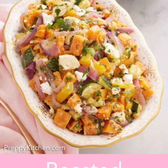 Pinterest graphic of a platter of roasted vegetable salad with chopped parsley and crumbled feta on top.