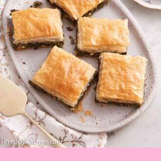 Pinterest graphic of a platter of five pieces of spanakopita.