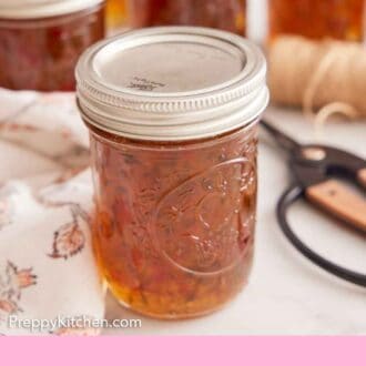 Pinterest graphic of multiple jars of jalapeno jelly with one front and center.