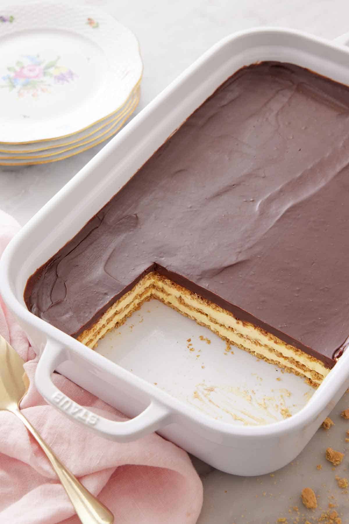 An angled view of an éclair cake in a baking dish with two slices cut out.
