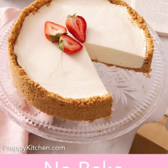 Pinterest graphic of a cake stand with a no bake cheesecake with three pieces of strawberries on top with a slice cut out.