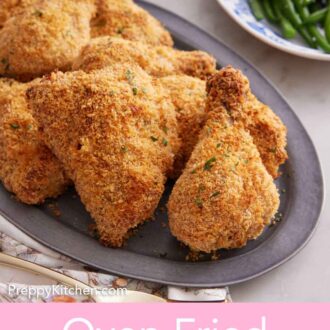 Pinterest graphic of a platter of oven fried chicken with plates of green beans and mashed potatoes in the background.