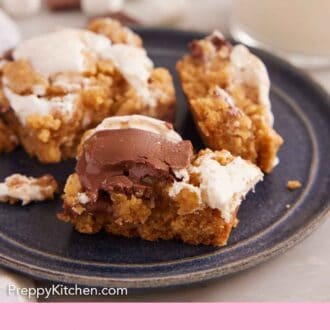 Pinterest graphic of a few bites of s'more bars on a dark plate. Milk, marshmallows, and chocolate in the background.