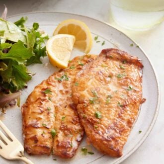 Pinterest graphic of a plate with sole meunière with two lemon wedges and a side of mixed greens.