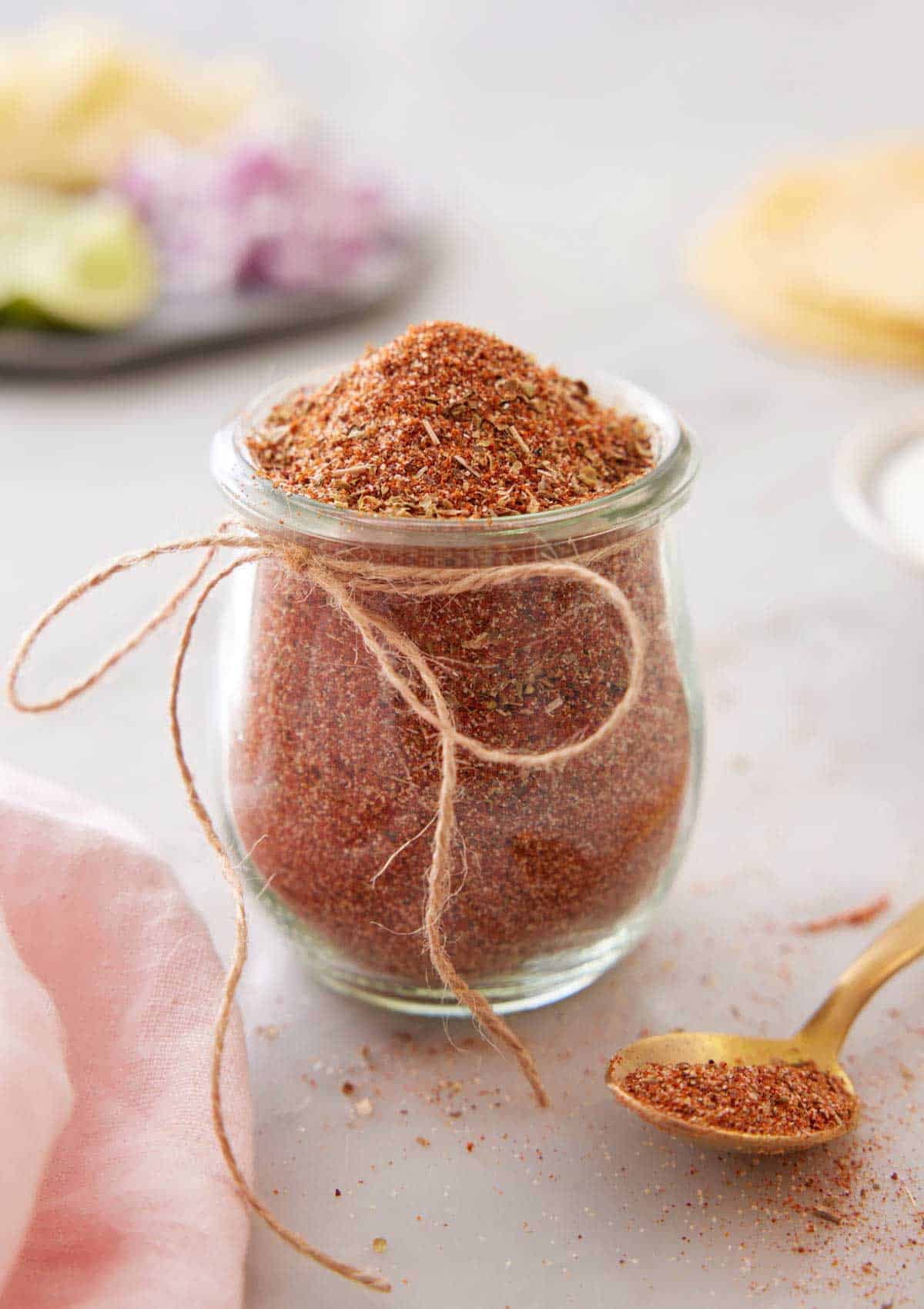 A small jar of taco seasoning with a string bow tied on.