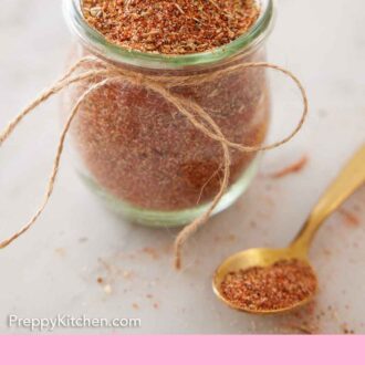 Pinterest graphic of a jar of taco seasoning with a spoonful placed beside it.