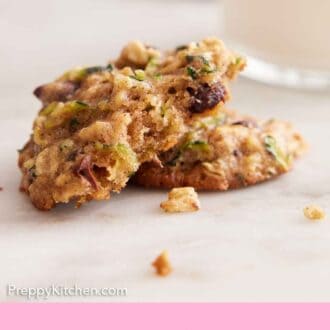 Pinterest graphic of a zucchini cookie torn in half with one half propped up, showing the interior.