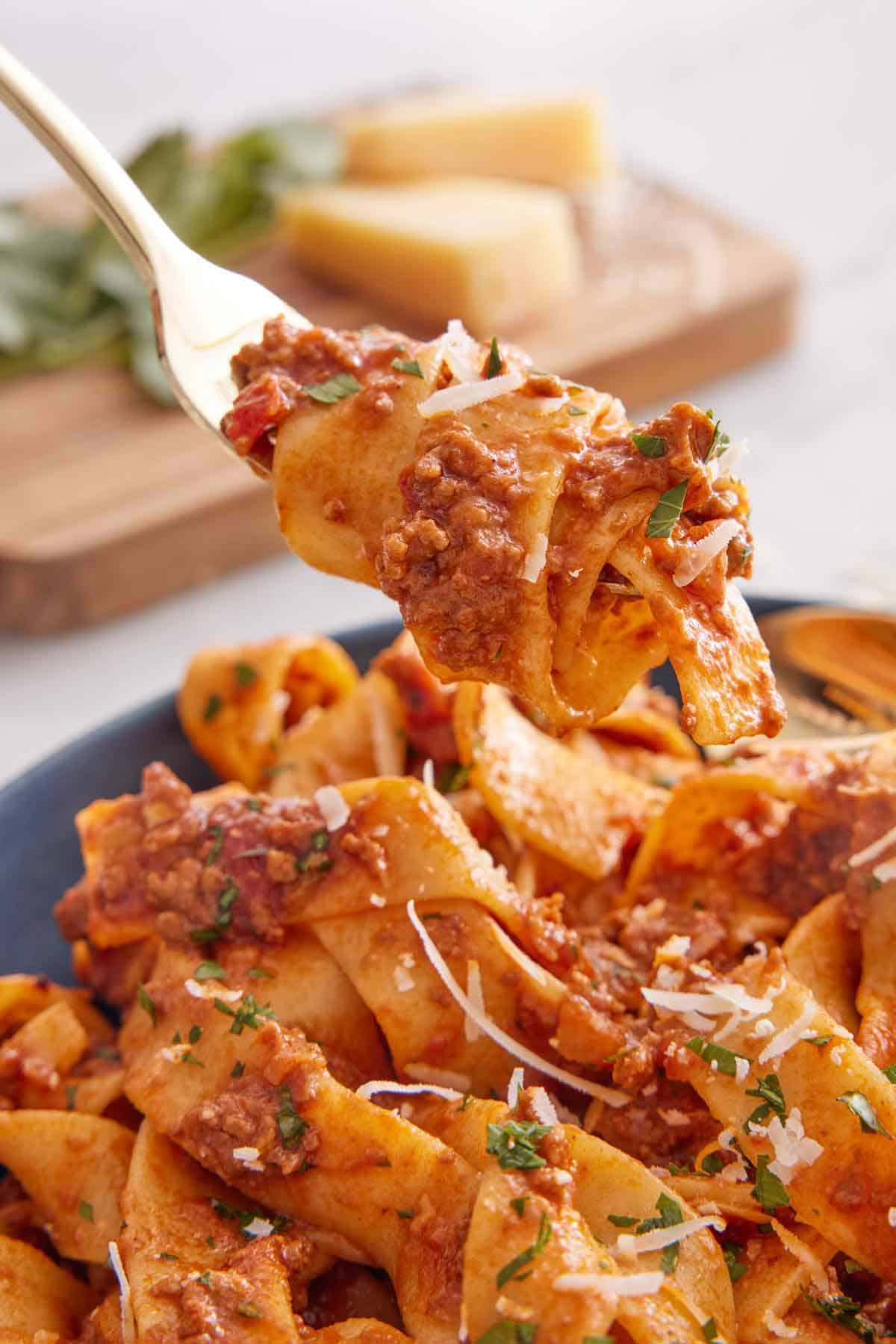 A forkful of bolognese lifted from a bowl.