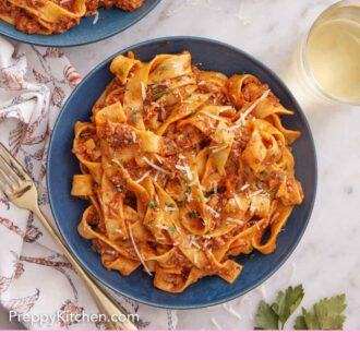 Pinterest graphic of plated bolognese with some wine and cheese off to the side.