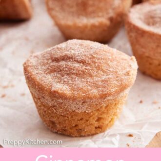 Pinterest graphic of a cinnamon muffin on a parchment paper with more in the background.