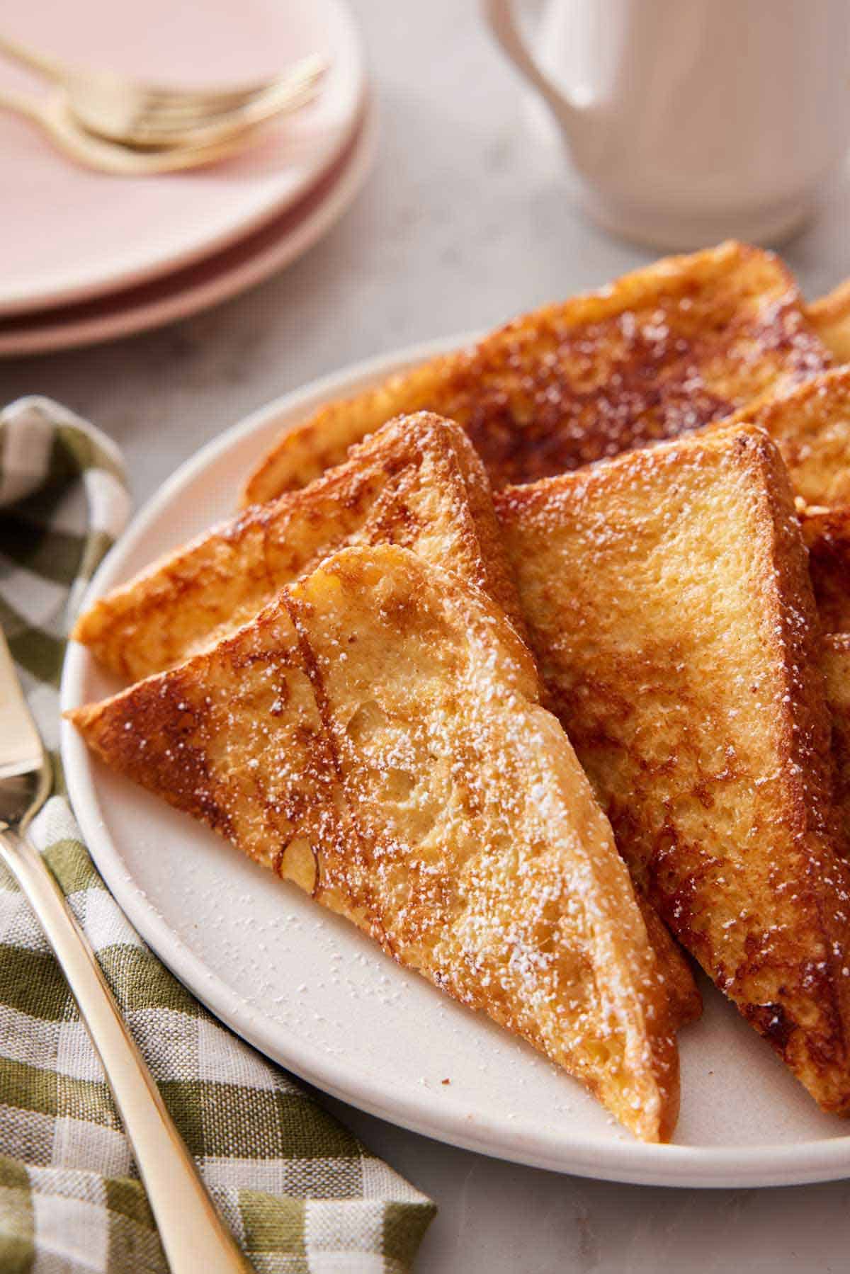 A plate with multiple pieces of french toast cut into triangles.