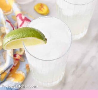 Pinterest graphic of a slightly overhead view of two glasses of ranch water with lime wedges on the rim.