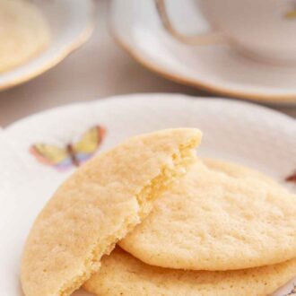 Pinterest graphic of a stack of two tea cakes on a plate with a half tea cake leaning on top.