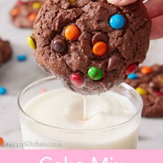Pinterest graphic of a cake mix cookie topped with M&M's dunked into a glass of milk and lifted up.