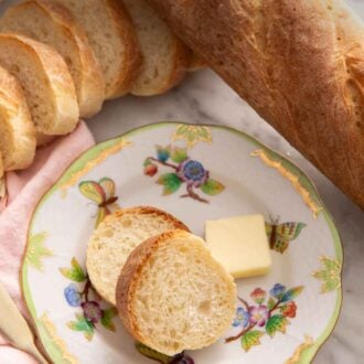 Pinterest graphic of a plate with two slices of French bread with a knob of butter surrounded by more loaves of French bread.