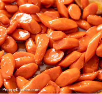 Pinterest graphic of a skillet of glazed carrots with a wooden spoon in the background.