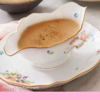 Pinterest graphic of a gravy boat of gravy with mashed potatoes and a stack of plates in the background.