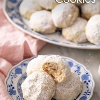 Pinterest graphic of a plate with multiple Mexican wedding cookies, one on top with a bite taken out.