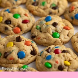 Pinterest graphic of multiple monster cookies, side by side, on parchment paper.