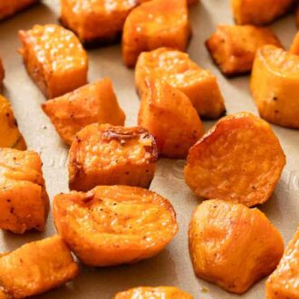 A close up view of roasted sweet potatoes on a sheet pan.