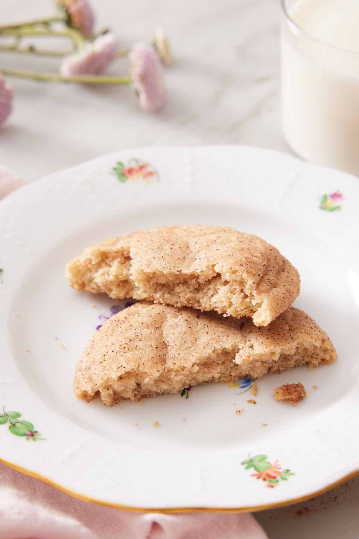A plate with a snickerdoodle cookie torn in half, showing the interior.