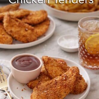 Pinterest graphic of a plate with air fryer chicken tenders on a plate with bbq sauce. More tenders, some french fries, and an iced drink in the background.
